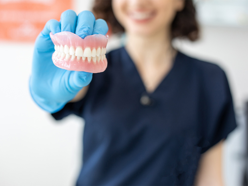Dental assistant holding a set of dentures