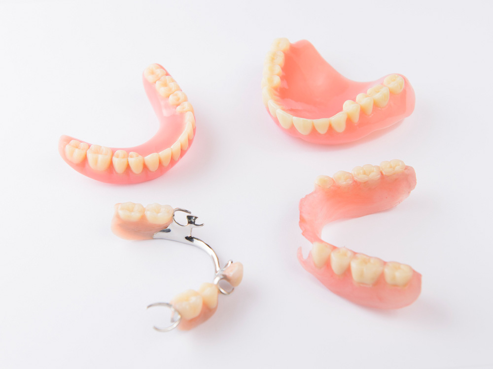 Full and partial dentures on white background